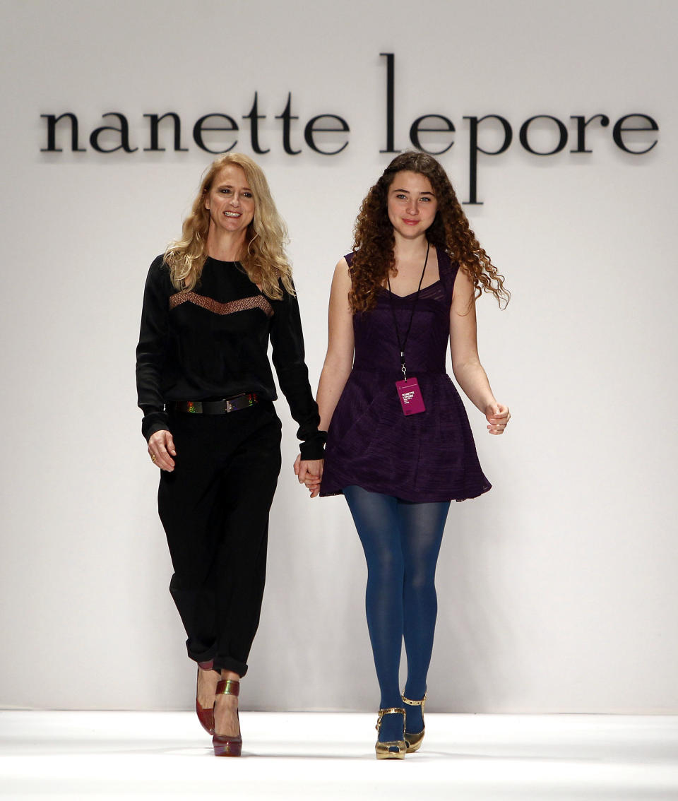 Designer Nanette Lepore, left, is joined by her daughter Violet as she acknowledges the audience after the Nanette Lepore Fall 2013 collection show during Fashion Week, Wednesday, Feb. 13, 2013 in New York. (AP Photo/Jason DeCrow)