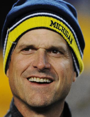 FILE - In this Jan. 3, 2015, file photo, new Michigan football coach, Jim Harbaugh watches is brother, coach the Baltimore Ravens, before an NFL wildcard playoff football game in Pittsburgh. (AP Photo/Don Wright, File)