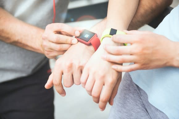 Two wrists wearing fitness trackers