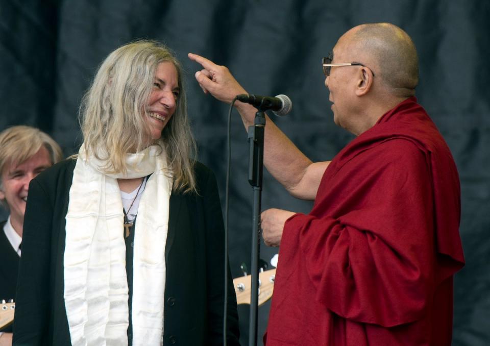 Tibetan spiritual leader, the Dalai Lama (R) joins US singer-songwriter Patti Smith (L) on The Pyramid Stage in 2015 (EPA)