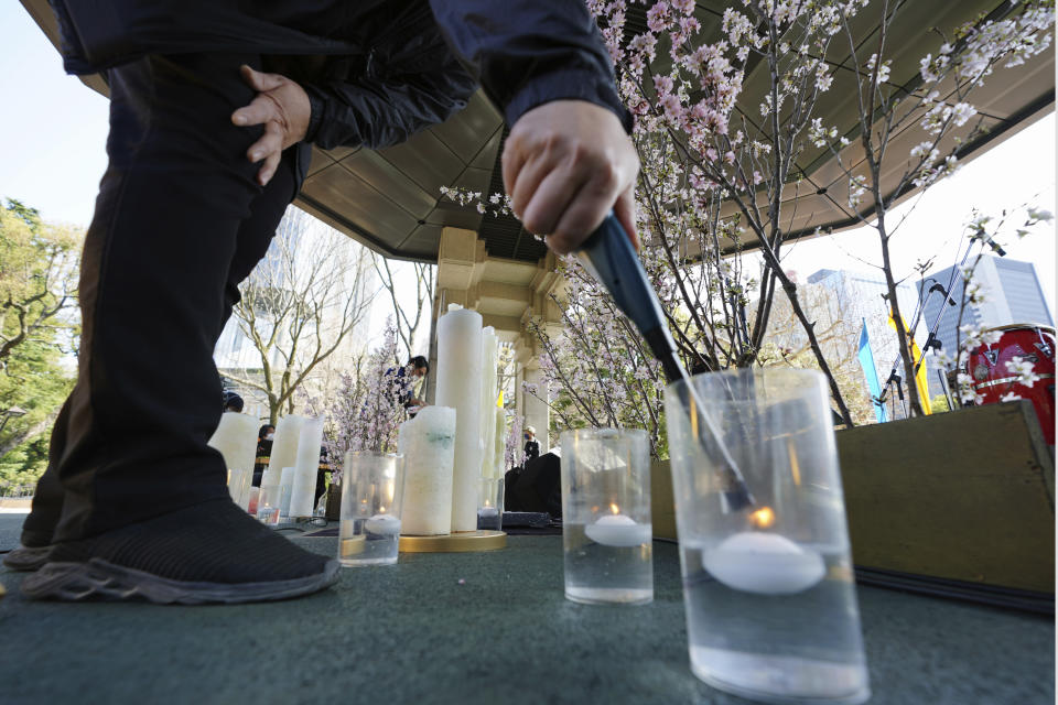 A staff member prepares the decoration to mourn for the victims of the 2011 earthquake and tsunami prior to an online special memorial event at Hibiya Park in Tokyo Thursday, March 11, 2021. Japan on Thursday marked the 10th anniversary of the massive earthquake, tsunami and nuclear disaster that struck Japan's northeastern coast. (AP Photo/Eugene Hoshiko)