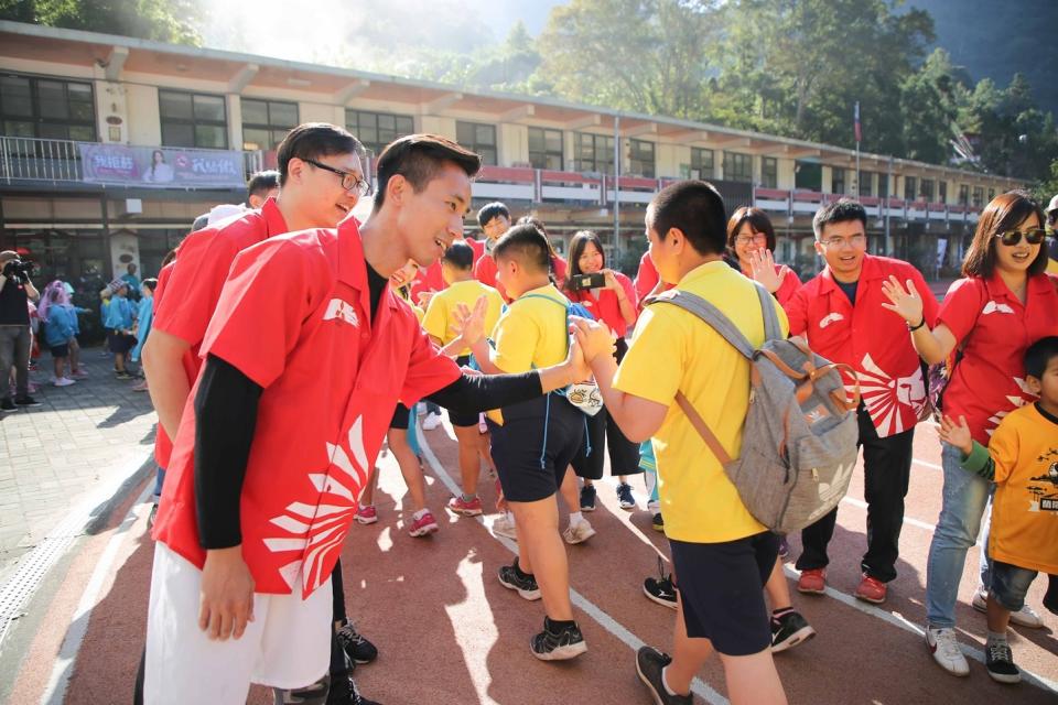 中華三菱志工列隊歡迎五峰國小小朋友參加跨校聯合運動。