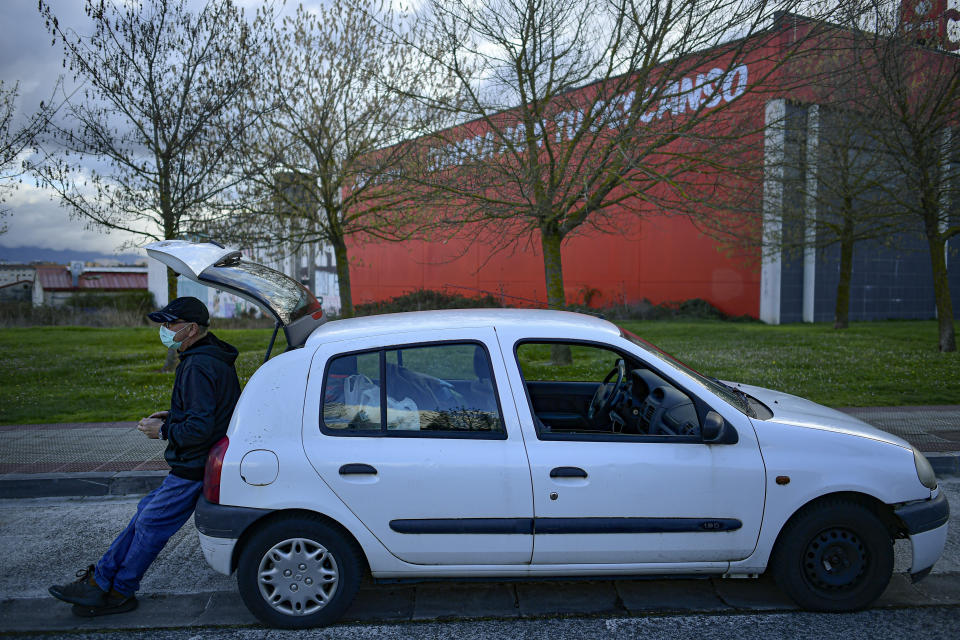 Javier Irure, 65, leans on his car which is now his home, in Pamplona, northern Spain, Friday, March 19, 2021. Javier Irure had only one possible roof to put over his head when the 65-year-old Spaniard was evicted after the economic slowdown caused by the coronavirus pandemic destroyed his financial stability. Irure said from his old Renault Clio compact that has provided him with shelter for the past three months. (AP Photo/Alvaro Barrientos)