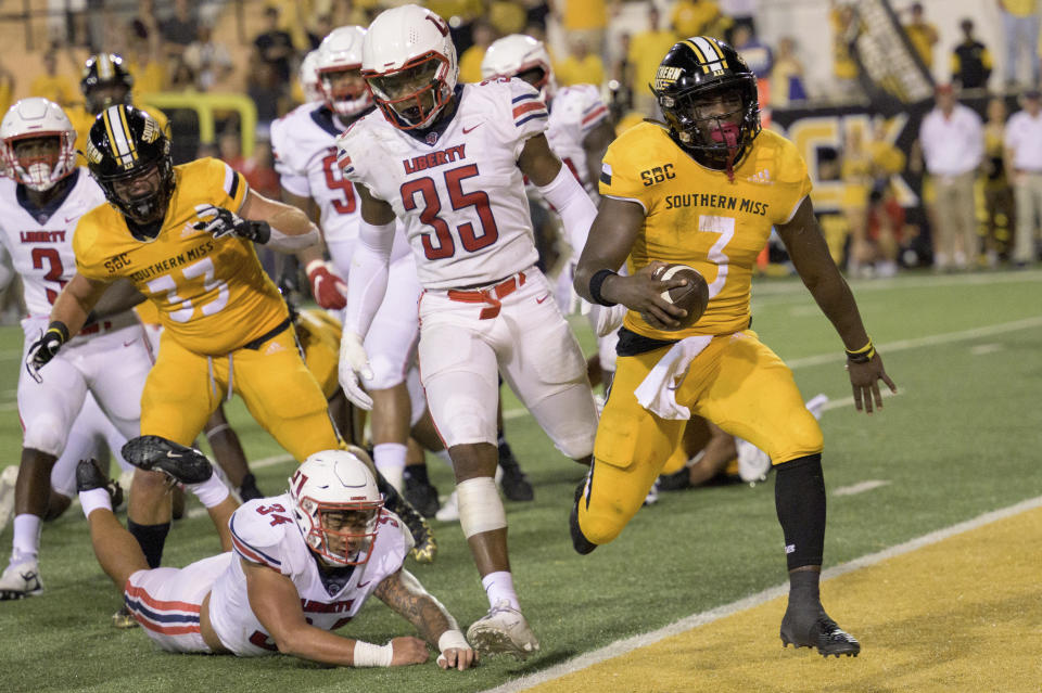 FILE - Southern Miss running back Frank Gore Jr. (3) scores while filling in as quarterback against Liberty linebacker Ahmad Walker (34) dives after him during the second half of an NCAA football game on Friday, Sept. 3, 2022, in Hattiesburg, Miss. The son of one of the NFL’s most prolific running backs made quite a name for himself this bowl season. (AP Photo/Matthew Hinton, File)