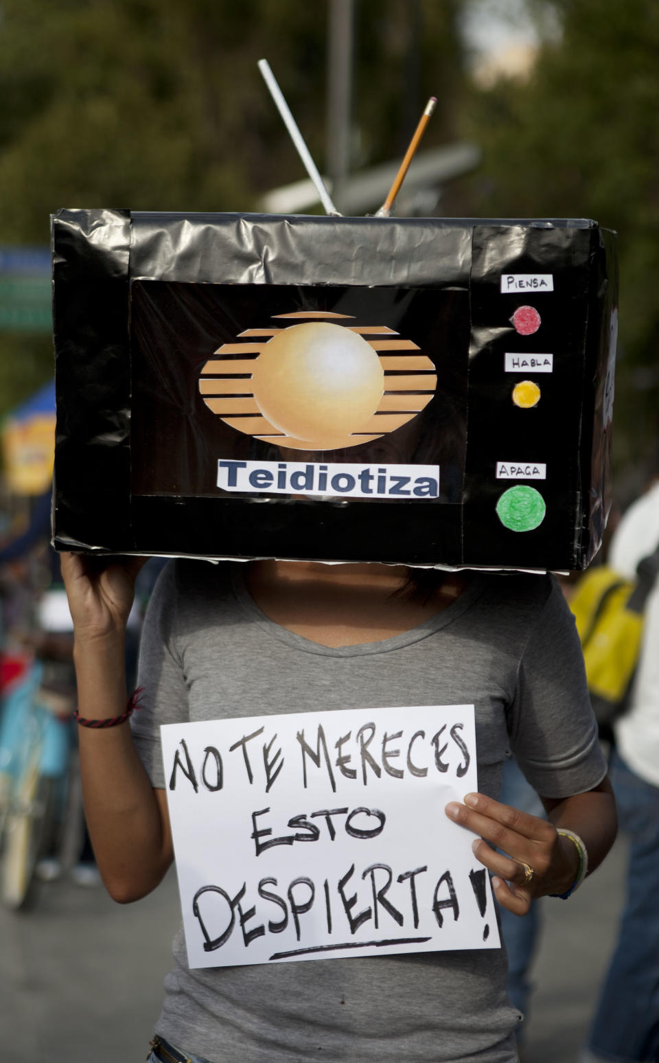 A student holds signs during a demonstration to protest a possible return of the old ruling Institutional Revolutionary Party (PRI) and against what they perceive as a biased coverage by major Mexican TV networks directed in favor of PRI's candidate Enrique Pena Nieto in Mexico City, Wednesday, May 23, 2012. The sign reads in Spanish: "You don't deserve it, wake-up!". Mexico will hold presidential elections on July 1. (AP Photo/Eduardo Verdugo)