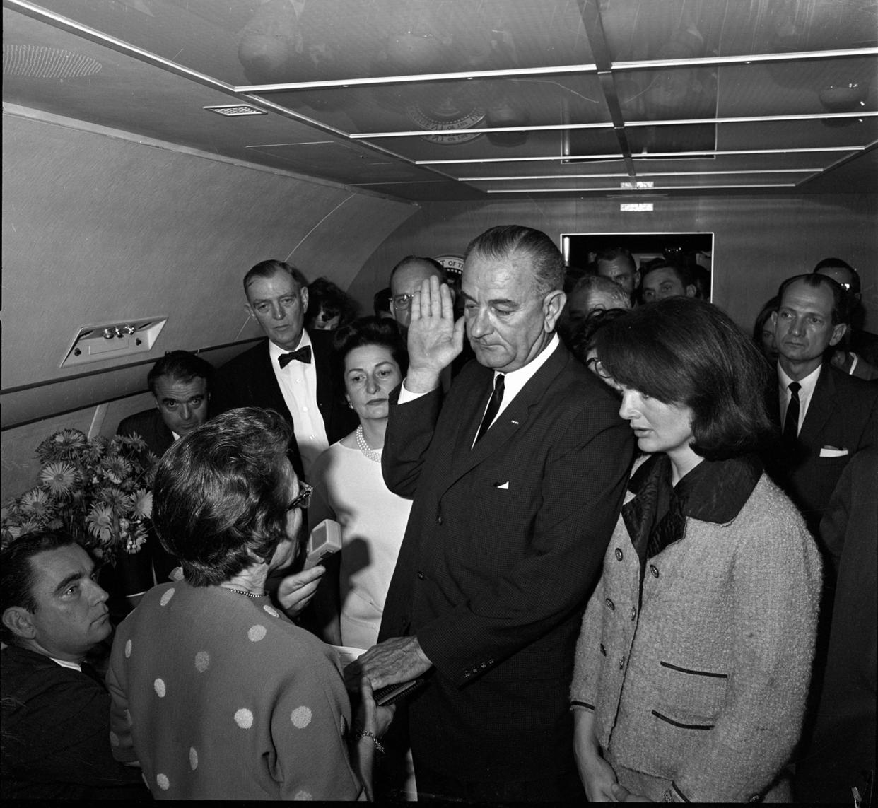Lyndon Johnson takes the oath of office aboard Air Force One after the assassination of John F. Kennedy.
