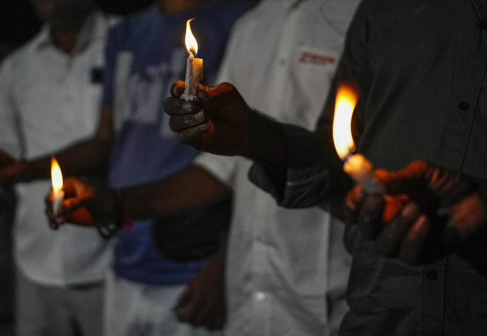 <p>People light candles to pay tribute to victims of Sunday's bridge collapse in Morbi town, in the western Indian state of Gujarat, Monday, Oct. 31, 2022. Military teams were searching Monday for people missing after a 143-year-old suspension bridge collapsed into a river Sunday in the western Indian state of Gujarat, sending hundreds plunging into the water and killing at least 133 in one of the country's worst accidents in years. (AP Photo/Rafiq Maqbool)</p> 