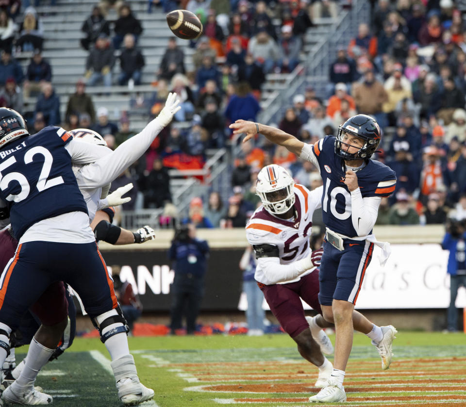 Virginia quarterback Anthony Colandrea (10) throws a pass as he is pressured the the Virginia Tech pass rush during the first half of an NCAA college football game Saturday, Nov. 25, 2023, in Charlottesville, Va. (AP Photo/Mike Caudill)