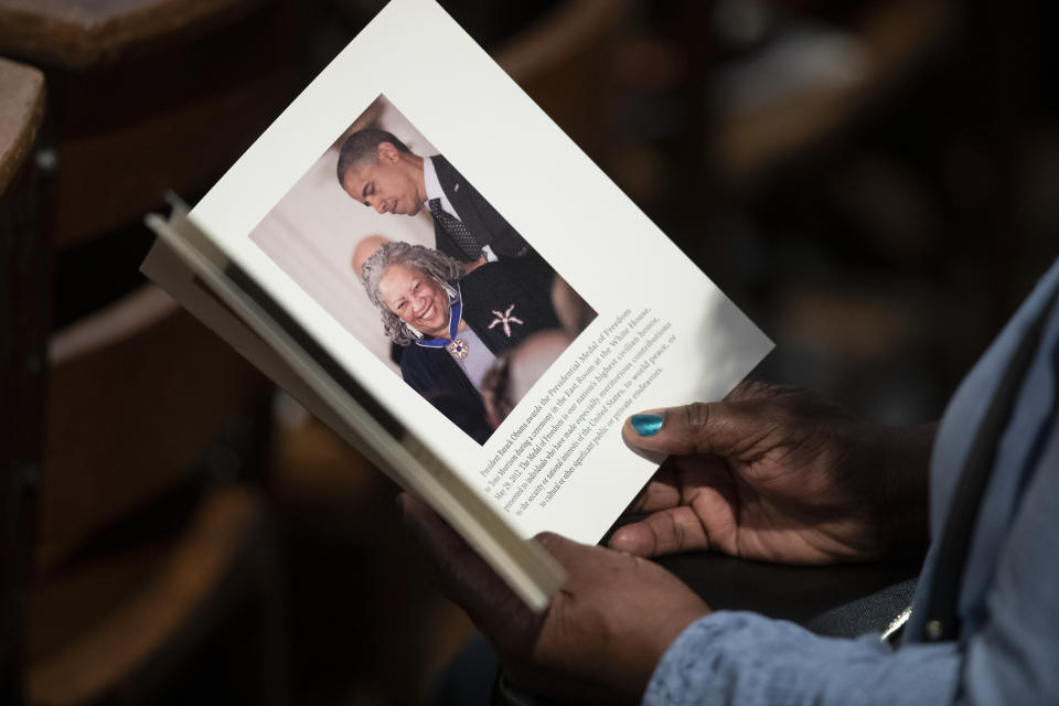 A person looks through the program before the start of the Celebration of the Life of Toni Morrison, Thursday, Nov. 21, 2019, at the Cathedral of St. John the Divine in New York. (AP Photo/Mary Altaffer)