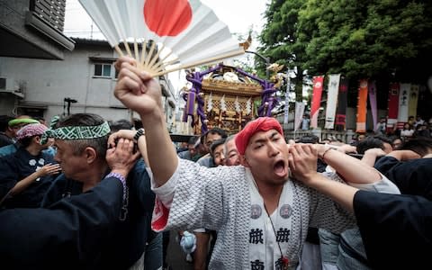 People carry a portable shrine or "mikoshi" during a ceremony to celebrate the accession of the new emperor - Credit: BEHROUZ MEHRI/AFP/Getty Images