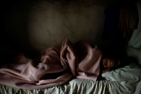 Aurana Augustin, known as Timatant, a vendor, rests on a bed in Boucan Ferdinand, Haiti, October 10, 2018. Timatant has a partial paralysis that impedes her to do her job. "There are no doctors here. It's easier to go to Duverger (Dominican Republic). There is a truck to go there," she said. REUTERS/Andres Martinez Casares