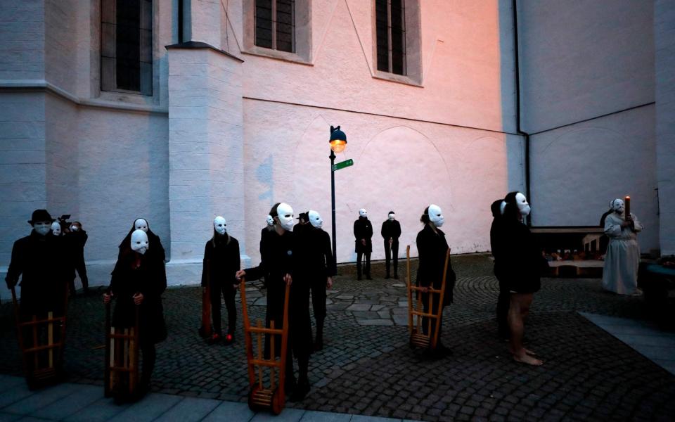 Participants wearing masks take part in an Easter procession marching through the streets of Ceske Budejovice. The traditional event went ahead despite Covid-19 restrictions, although participants also wore medical face masks and observed social distancing as a precaution - AP Photo/Petr David Josek