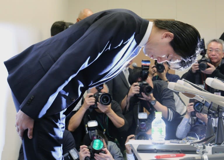 Liberal Democratic Party lawmaker Kensuke Miyazaki bows at a Tokyo press conference announcing his resignation on February 12, 2016 after a weekly magazine revealed his affair