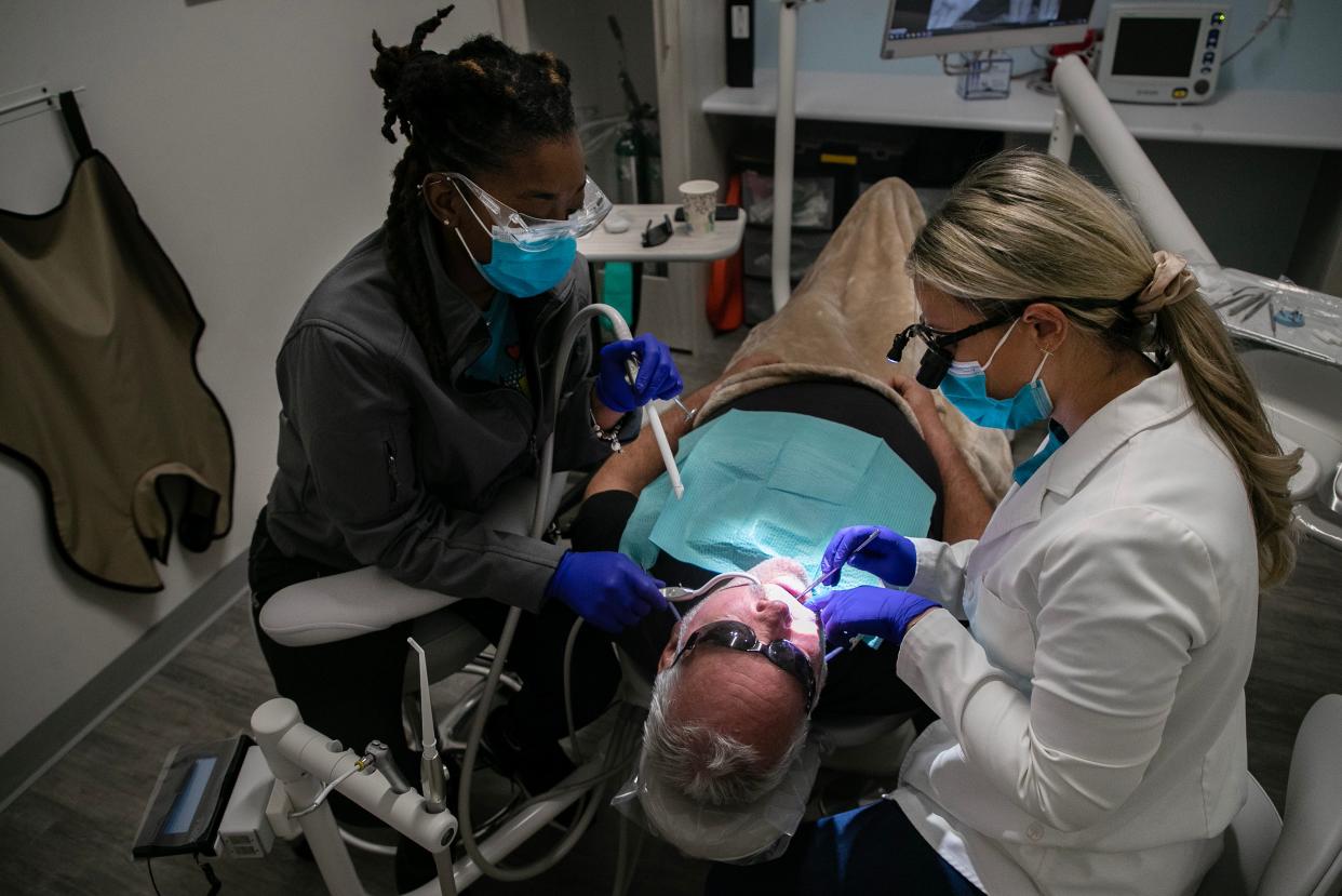 Dr. Katelyn Butch, right, and lead dental assistant Bianca Jean, left, help Clay Chabot with some of his dental issues at at Dentists of Fort Myers on Saturday, Aug. 19, 2023, in Fort Myers. The dental office is helping Chabot and five other patients as a part of their company's Serve Day.