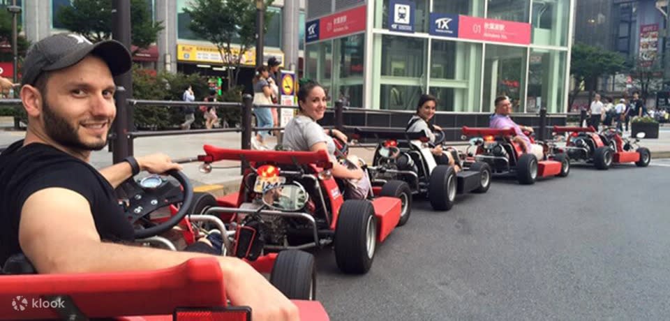 A photo of tourists riding go-karts in Tokyo.