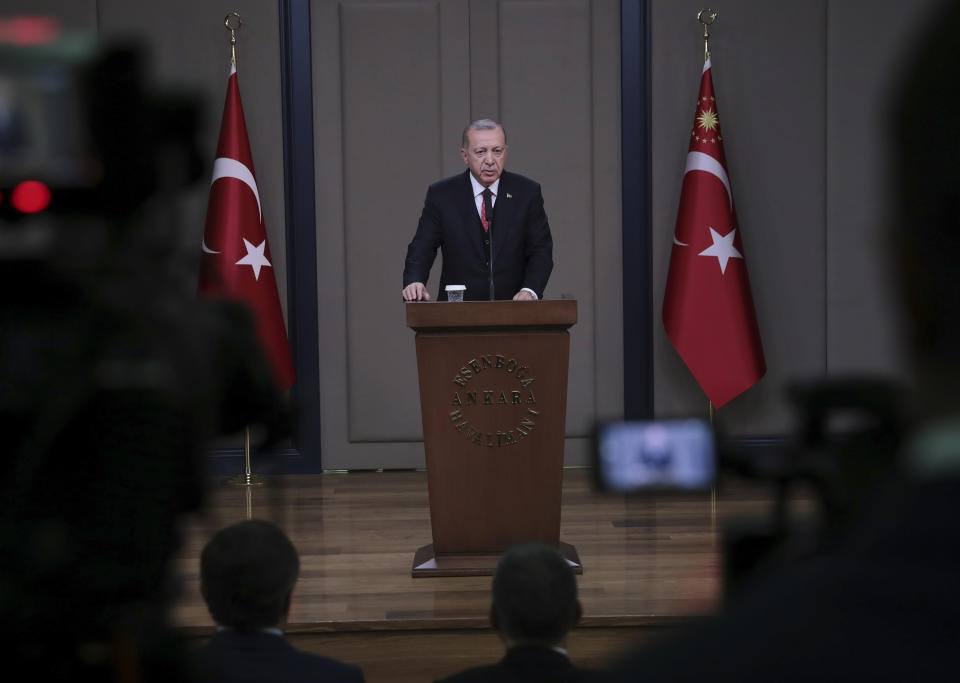 Turkey's President Recep Tayyip Erdogan talks to members of the media at the airport in Ankara, Turkey before departing to France, Saturday, Nov. 10, 2018. Erdogan said at the news conference that officials from Saudi Arabia, the United States, Germany, France and Britain have listened to audio recordings related to the killing of journalist Jamal Khashoggi at the Saudi Consulate in Istanbul. Erdogan's comments were the first public confirmation of the existence of recordings of the Oct. 2 killing of The Washington Post columnist at the consulate. (Presidential Press Service via AP, Pool)