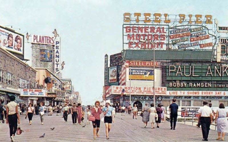 Looking up the Boardwalk towards the Steel Pier, about 1963. Rooftop signs advertise the General Motors exhibit, a long-running attraction featuring new cars every season. The Planters Peanuts store on on the left.