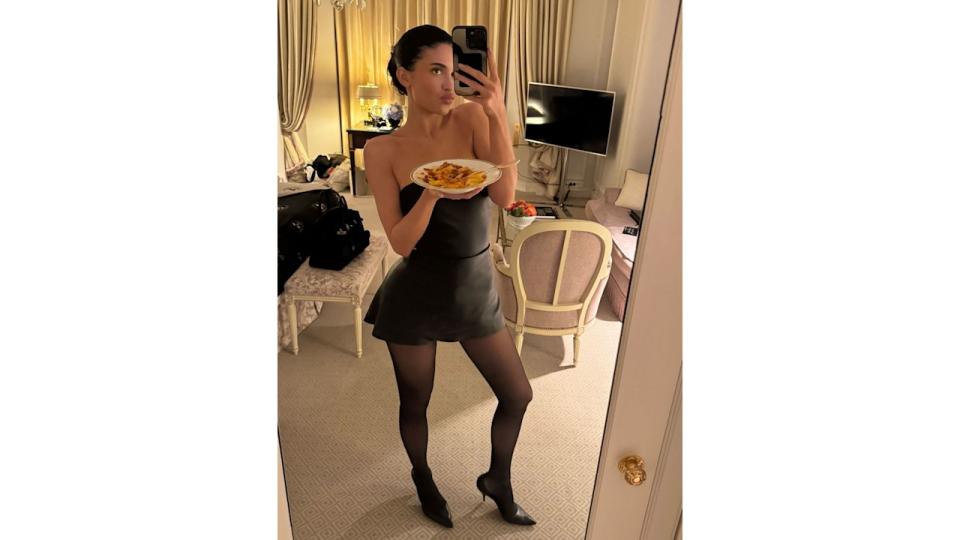 Kylie Jenner poses for a mirror selfie in a black mini dress and sheer tights