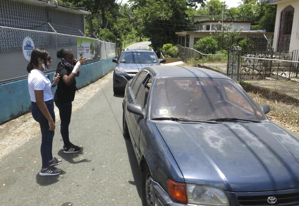 Electoral officials inform arriving voters that the ballots haven't arrived at a voting center in Carolina, Puerto Rico, Sunday, Aug. 9, 2020. Puerto Rico's primaries were marred on Sunday by a lack of ballots in a majority of centers across the U.S. territory, forcing frustrated voters who braved a spike in COVID-19 cases to turn around and go back home. (AP Photo/Danica Coto)