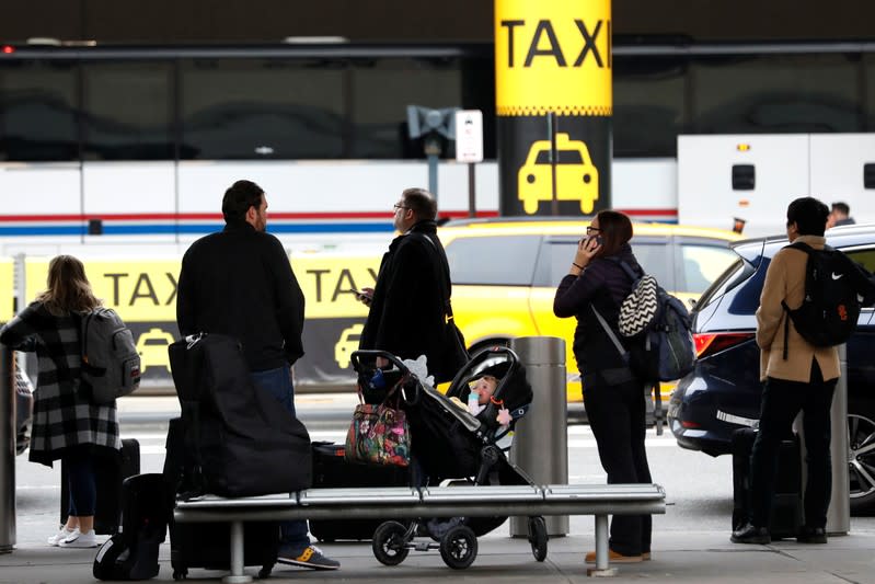 Travelers await ground transportation at Newark International Airport ahead of the Thanksgiving holiday in Newark