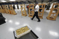 FILE - In this July 16, 2019, file photo, an officer taking part in training walks near a box of ammunition at the Washington State Criminal Justice Training Commission in Burien, Wash. The COVID-19 pandemic coupled with record sales of firearms have created a shortage of ammunition in the United States that has impacting competition and recreational shooters, hunters, people seeking personal protection and law enforcement agencies. (AP Photo/Ted S. Warren, File)