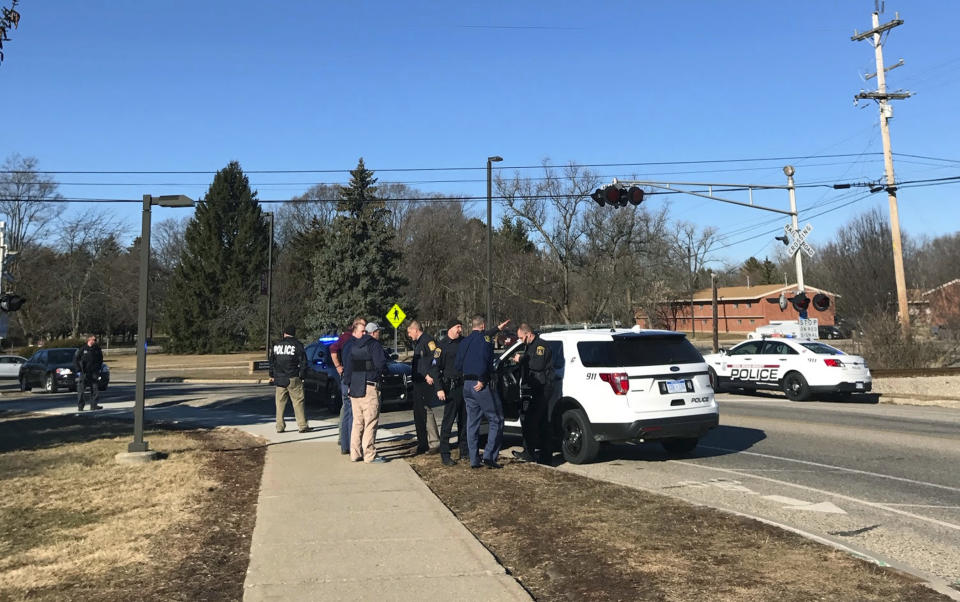 Authorities stand on the campus of Central Michigan University during a search for a suspect, in Mount Pleasant, Mich., Friday, March 2, 2018. School officials say police are responding to a report of shots fired at a residence hall at the university.