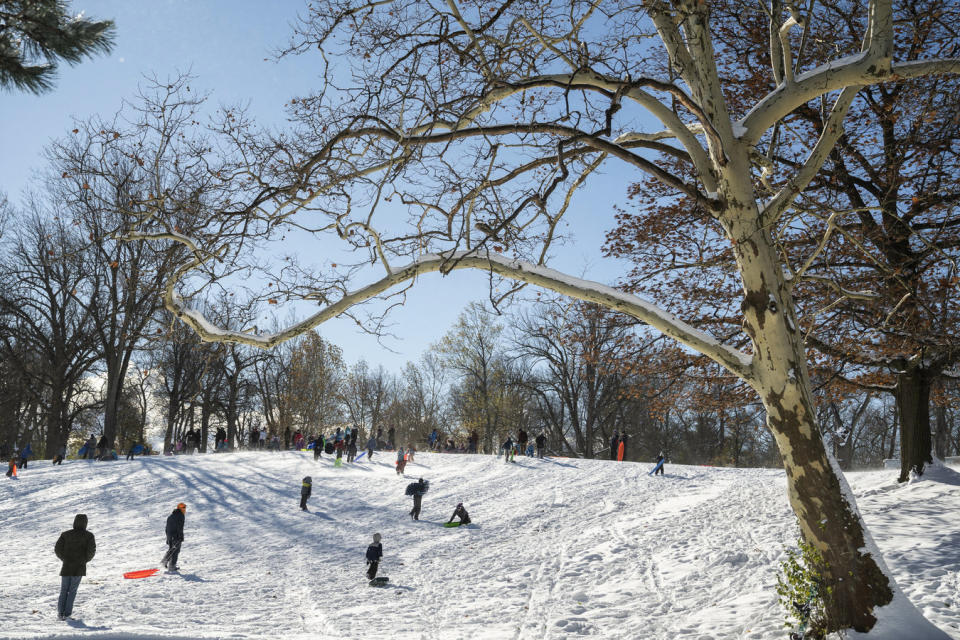 Families enjoy sledding, taking advantage of two days of lake-effect snow at Delaware Park in Buffalo, N.Y., Sunday, Nov. 20, 2022. Just south of Buffalo, towns are still working to clear the snowy aftermath of the lake-effect storm, but in parts of the city, normalcy is beginning to return. (Libby March/The Buffalo News via AP)