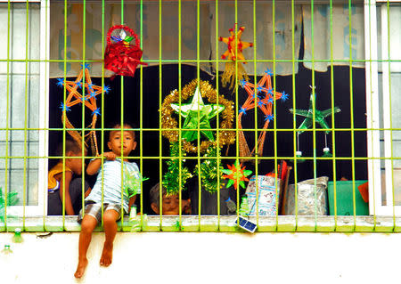 A boy sits at a window as he celebrates Christmas Day at the evacuation center before Typhoon Nock-ten is expected to strike Legazpi City, Albay province, central Philippines December 25, 2016. REUTERS/Stringer