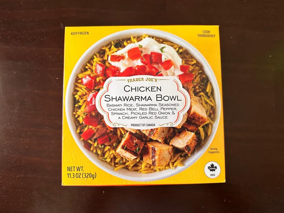 A bright-yellow box with an image of a bowl of rice, peppers, a white sauce, and chicken pieces with a white label saying "chicken shawarma bowl"