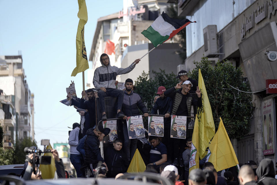 Palestinians hold posters of Palestinian prisoner Nasser Abu Hamid during a protest, Tuesday, Dec. 20, 2022, in the West Bank city of Ramallah, after he died of lung cancer in Israel. Abu Hamid was a former leader of the Al Aqsa Martyrs' Brigade, the armed wing of Palestinian President Mahmoud Abbas's Fatah party. He had been serving seven life sentences after being convicted in 2002 for involvement in the deaths of seven Israelis during the second Palestinian intifada, or uprising, against Israel's occupation in the early 2000s. (AP Photo/Majdi Mohammed)