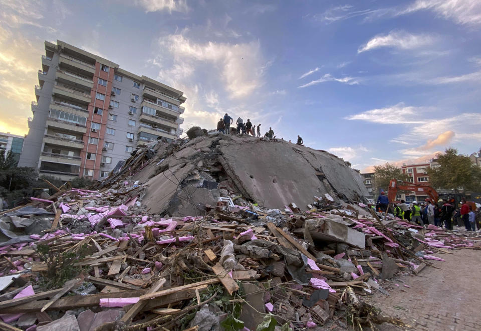 Rescue workers try to save people trapped in the debris of a collapsed building, in Izmir, Turkey, Friday, Oct. 30, 2020. A strong earthquake struck Friday in the Aegean Sea between the Turkish coast and the Greek island of Samos, killing several people and injuring hundreds amid collapsed buildings and flooding, officials said.(AP Photo/Ismail Gokmen)