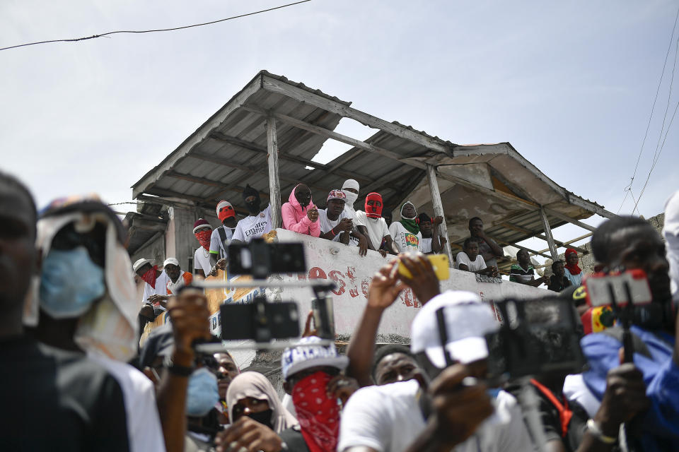 Members of the gang led by Jimmy Cherizier, alias Barbecue, a former police officer who heads a gang coalition known as "G9 Family and Allies," watch a march to demand justice for slain Haitian President Jovenel Moise in La Saline neighborhood of Port-au-Prince, Haiti, Monday, July 26, 2021. Moise was assassinated on July 7 at his home. (AP Photo/Matias Delacroix)