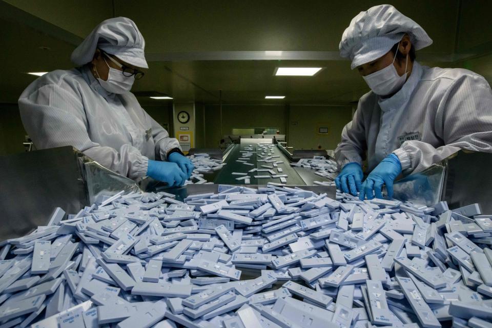 Sample testing devices used in diagnosing the COVID-19 novel coronavirus are checked on a production line as they are prepared to be included in testing kits for shipment at the SD Biosensor bio-diagnostic company near Cheongju, south of Seoul on March 27, 2020. - SD Biosensor is one of five companies in South Korea -- which appears to have brought its epidemic under control with a huge "trace, test and treat" effort -- making diagnostic tests for the COVID-19 virus. (Photo by Ed JONES / AFP) (Photo by ED JONES/AFP via Getty Images)