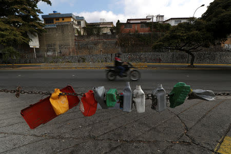 Plastic containers hang at a closed petrol station during a blackout in Caracas, Venezuela March 27, 2019. REUTERS/Ivan Alvarado