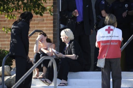 A distraught woman is counseled by Pastor Quincy Shannon (L) of the New Hope Fellowship and an unidentified advocate in front of Gateway High School in Aurora, Colorado where the families of the missing are meeting following the shooting at the Century 16 movie theater