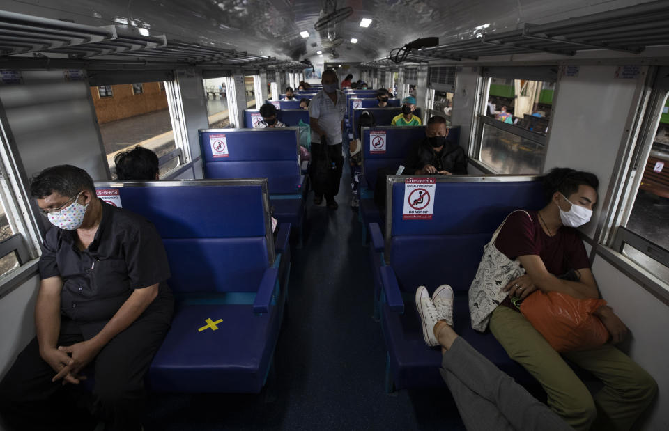 Passengers on a train with staggered seating wear face masks to curb the spread of the coronavirus at the Hua Lamphong Railway Station in Bangkok, Thailand, Tuesday, June 9, 2020. The Thai government continues to ease restrictions related to running business in capital Bangkok that were imposed weeks ago to combat the spread of COVID-19. (AP Photo/Sakchai Lalit)