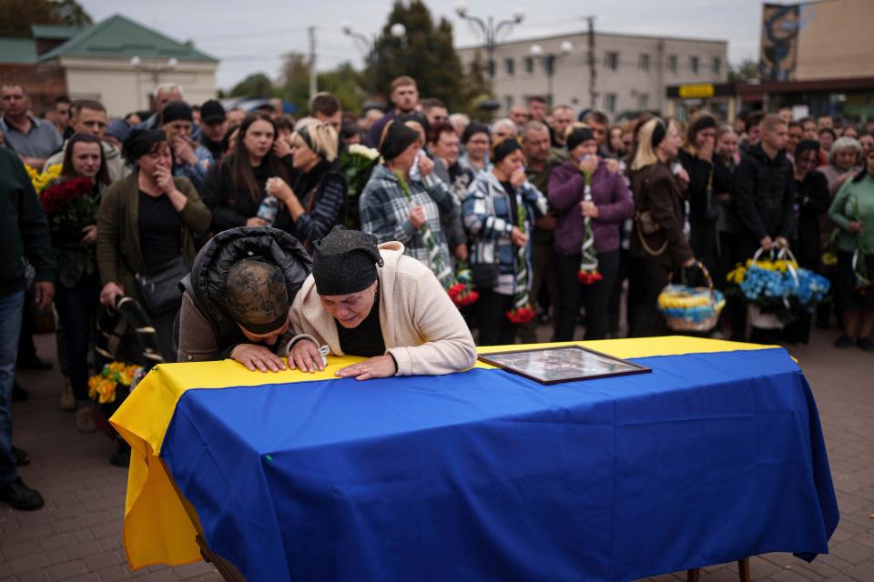 Mother Kateryna with her family cry over the coffin of her son Ihor Kusochek, Ukrainian soldier of the Azov brigade who was killed at the frontline in Toretsk, during the funeral ceremony in Bobrovytsia, Chernihiv region, Ukraine (AP)