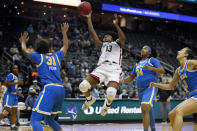 Connecticut guard Christyn Williams (13) drives to the basket between UCLA guard Jaelynn Penn (31) and forward IImar'I Thomas (24) during the second half of an NCAA college basketball game in Newark, N.J., Saturday, Dec. 11, 2021. Connecticut won 71-61. (AP Photo/Noah K. Murray)