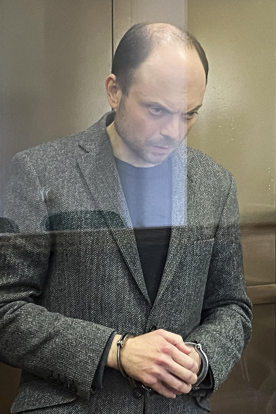 In this handout photo released by the Moscow City Court, Russian opposition activist Vladimir Kara-Murza stands in a glass cage in a courtroom at the Moscow City Court in Moscow, Monday April 17, 2023. A top Kremlin foe was convicted Monday on charges of treason and denigrating the Russian military and sentenced him to 25 years in prison after a trial that marked the latest move in a relentless crackdown on the opposition amid the fighting in Ukraine. (The Moscow City Court via AP)