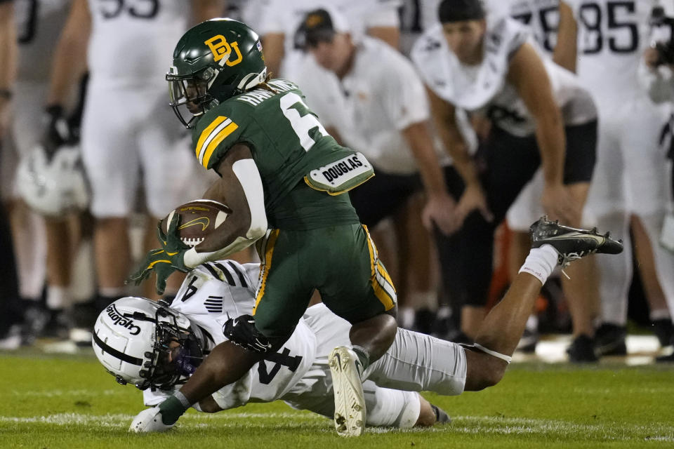 Baylor wide receiver Ashtyn Hawkins (6) tries to break a tackle by Iowa State defensive back Jeremiah Cooper (4) after catching a pass during the first half of an NCAA college football game, Saturday, Oct. 5, 2024, in Ames, Iowa. (AP Photo/Charlie Neibergall)