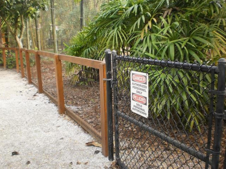 Structural safety barrier for tiger's enclosure with locked and posted access point.