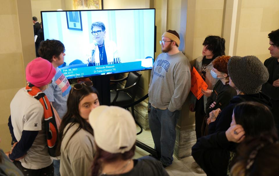 People gather around a live stream monitor Tuesday as Rep. Meloyde Blancett speaks. Supporters of Trans Oklahomans gathered to protest outside of the House chambers during debate on a bill to limit gender transition procedures.