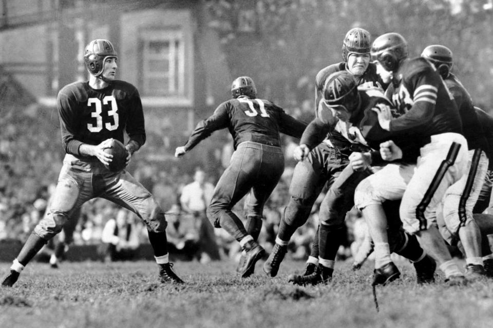 FILE - In this Sept. 13, 1942, file photo, Washington Redskins quarterback Sammy Baugh, left, drops back to pass against the Chicago Bears during a football game in Washington. Members of a special panel of 26 selected all of them for the position as part of the NFL's celebration of its 100th season. All won league titles except Marino. All are in the Hall of Fame except Brady and Manning, who are not yet eligible. On Friday, Dec. 27, 2019, quarterback was the final position revealed for the All-Time Team. (AP Photo/File)