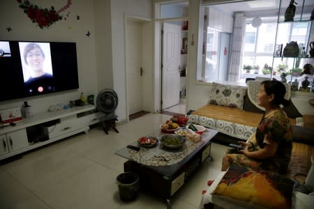 Zhao Xi'e, 55, chats with her sister as she performs the video chat function provided by Lanchuang's elderly care system during a media visit organised by the company in Weifang