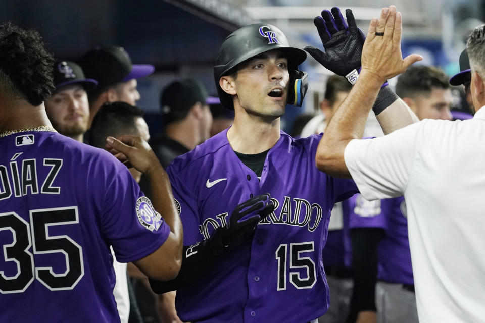Colorado Rockies' Randal Grichuk (15) celebrates with the team after hitting a home run to tie the game in the ninth inning of a baseball game against the Miami Marlins, Sunday, July 23, 2023, in Miami. (AP Photo/Marta Lavandier)