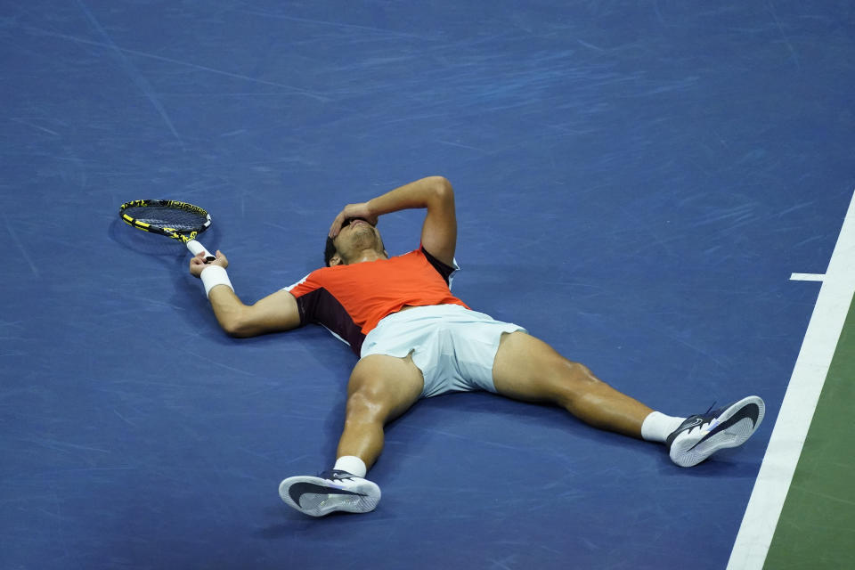 Carlos Alcaraz, tendido sobre la pista tras derrotar a Jannik Sinner en los cuartos de final del Abierto de Estados Unidos, el 8 de septiembre de 2022, en Nueva York. (AP Foto/Julia Nikhinson)