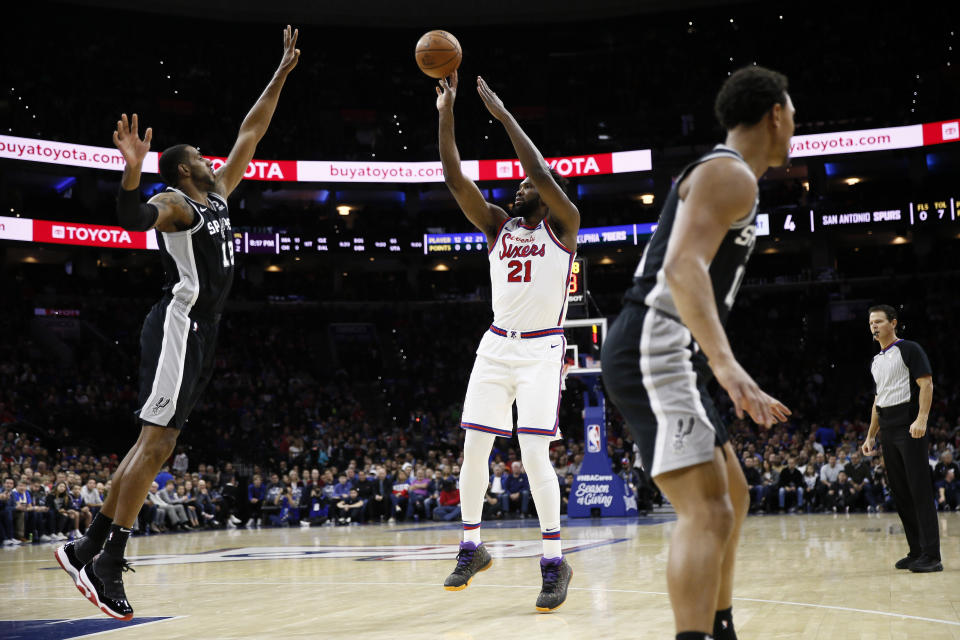 Philadelphia 76ers' Joel Embiid (21) goes up for a shot in front of San Antonio Spurs' LaMarcus Aldridge (12) during the first half of an NBA basketball game Friday, Nov. 22, 2019, in Philadelphia. (AP Photo/Matt Slocum)