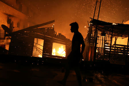 A resident is seen during a fire at Educando neighbourhood, a branch of the Rio Negro, a tributary to the Amazon river, in the city of Manaus, Brazil December 17, 2018. REUTERS/Bruno Kelly