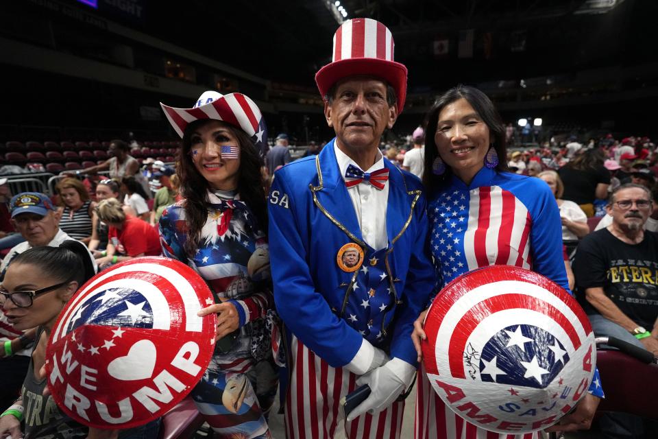 Jose Sanchez stands in between Sheila, left, and Kimberly, who both wanted to be referred to by the last name 'Trump', as they wait for the former President to take the stage at Findlay Toyota Center in Prescott Valley, Ariz. on Friday, July 22, 2022. "I take that name everywhere with me," said Sheila.