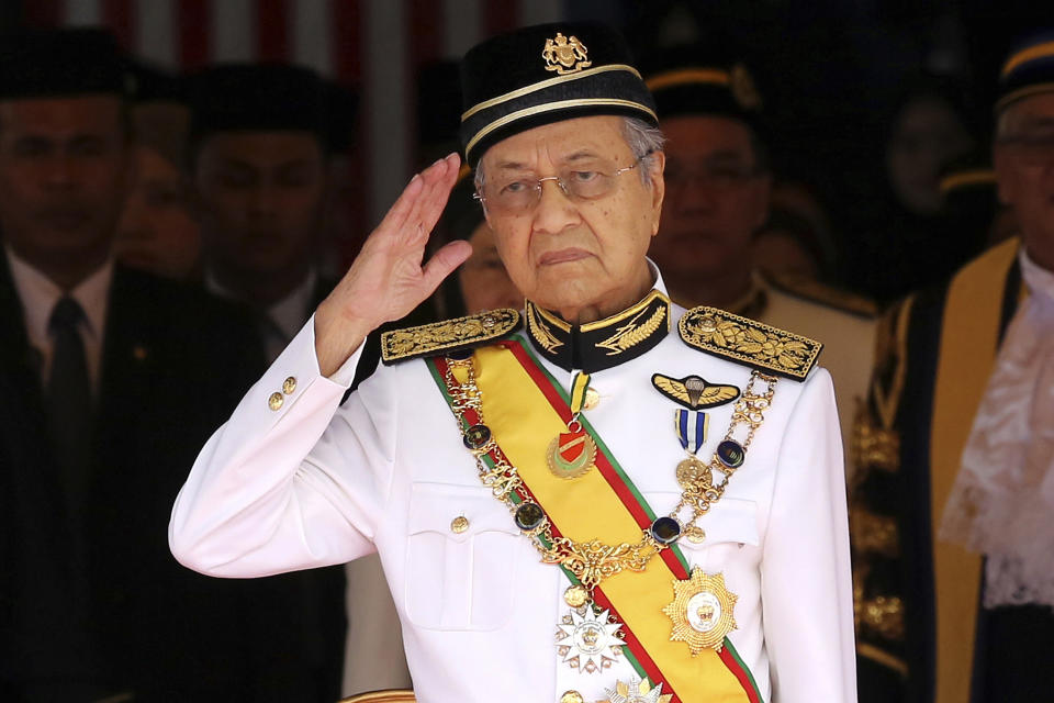 FILE - In this July 17, 2018, file photo, Malaysian Prime Minister Mahathir Mohamad salutes during the opening of the 14th parliament session at the Parliament house in Kuala Lumpur, Malaysia. Former Prime Minister Mahathir has been ousted from his Malay party in the latest twist to a power struggle with his successor Muhyiddin Yassin, but he has vowed to challenge the move. The 94-year-old Mahathir, along with his son and three other senior members, were expelled from the Bersatu party on Thursday, May 28, 2020. (AP Photo/Yam G-Jun, File)